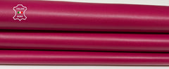 Close-up of raspberry-colored Italian lambskin leather skins by italianskins, showing smooth, genuine genuine genuine leather texture.